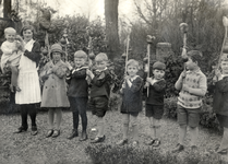 121410 Afbeelding van een groepje kinderen met palmpasenstokken.N.B. Op de achterzijde van de foto staat geschreven: ...